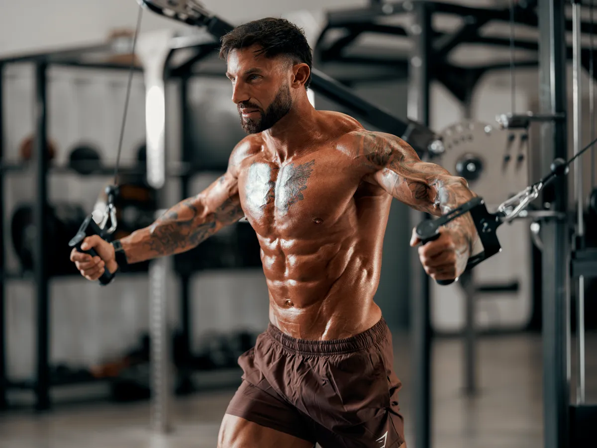 Cable fly from the front on the gym floor, mid rep